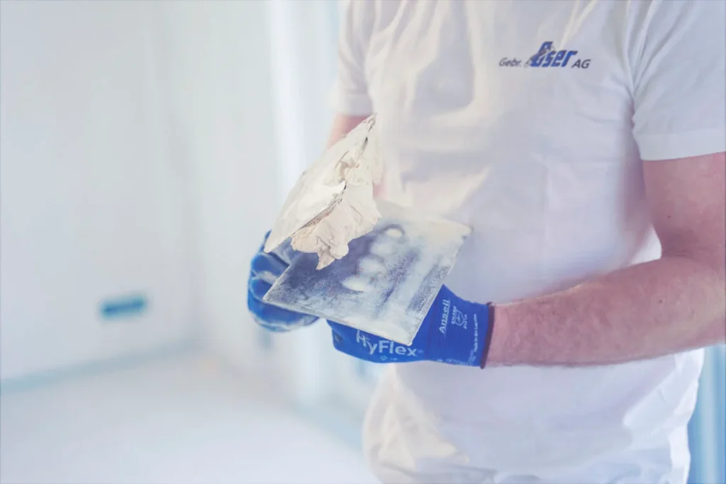 Gipser mit Spachtelmasse auf der Kelle